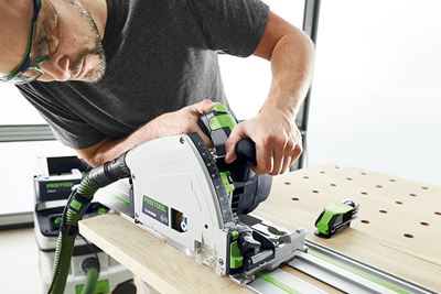 Mann mit Festool Kreissäge schneidet ein Brett auf einem Multifunktionstisch