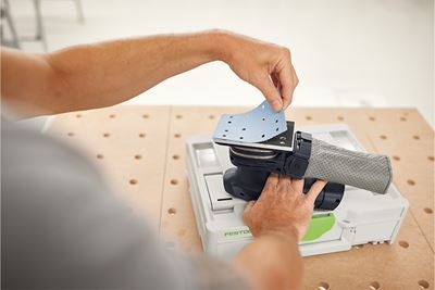 Handwerker bringt Schleifmittel an Schleifer an