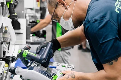 Die Bauteile der Festool Tauchsäge TSC 55 K werden an der Werkbank zusammengefügt.