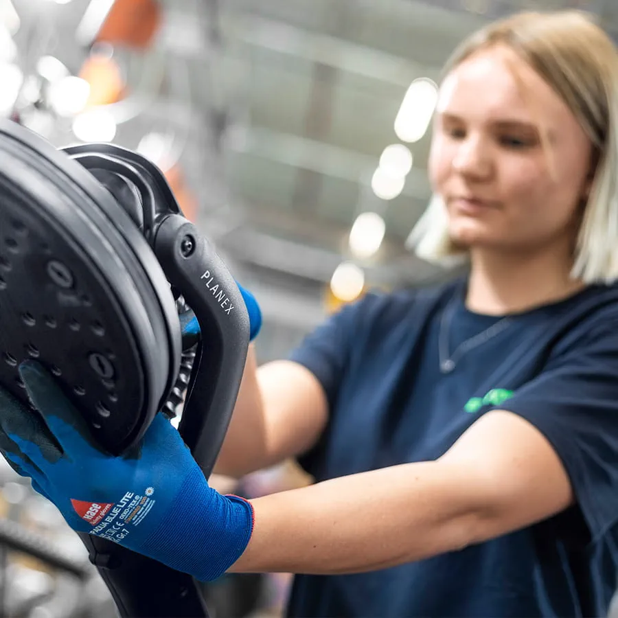 Im großzügigen Werk montieren Mitarbeitende an modernen Arbeitsstationen Elektrowerkzeuge.