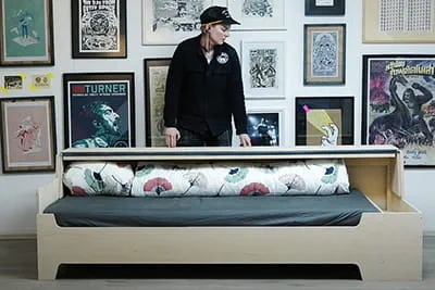 Laura Kampf steht hinter ihrer selbstgebauten Schlafcouch.